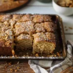 Freshly baked gluten-free sour cream coffee cake cut into squares with a golden cinnamon streusel topping
