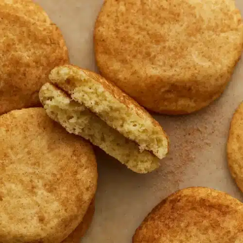 Close-up of gluten free snickerdoodle cookies recipe with crackly tops and soft centers on parchment paper