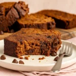 Moist gluten free pumpkin banana bread slice with chocolate chips on plate